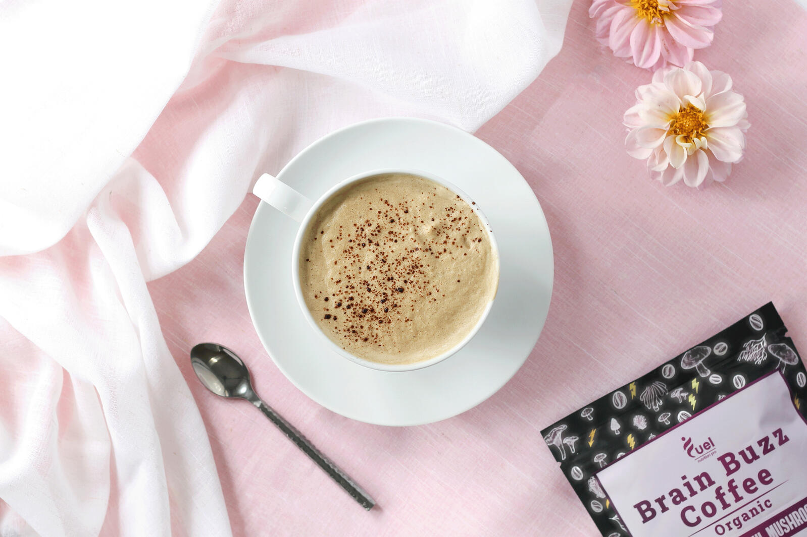 A latte with a branded mushroom coffee packages.